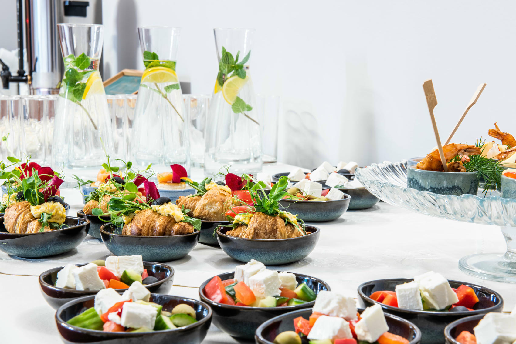 Stół z przekąskami: croissanty z pastą jajeczną, warzywa z fetą