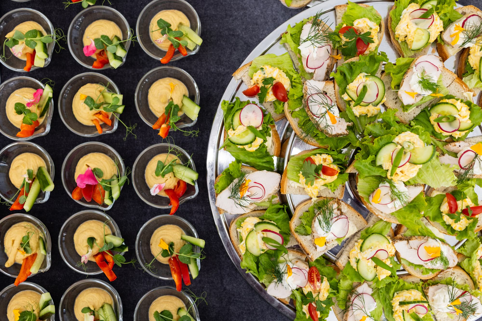 Talerz kanapek z jajecznym nadzieniem i warzywami, hummus po lewej