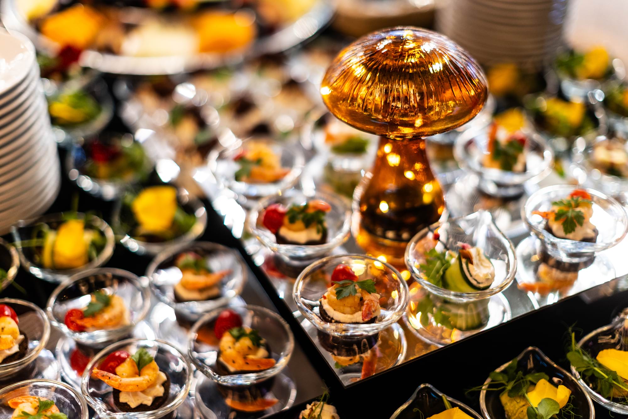 Złota dekoracja na środku stołu z przystawek w szklanych miseczkach