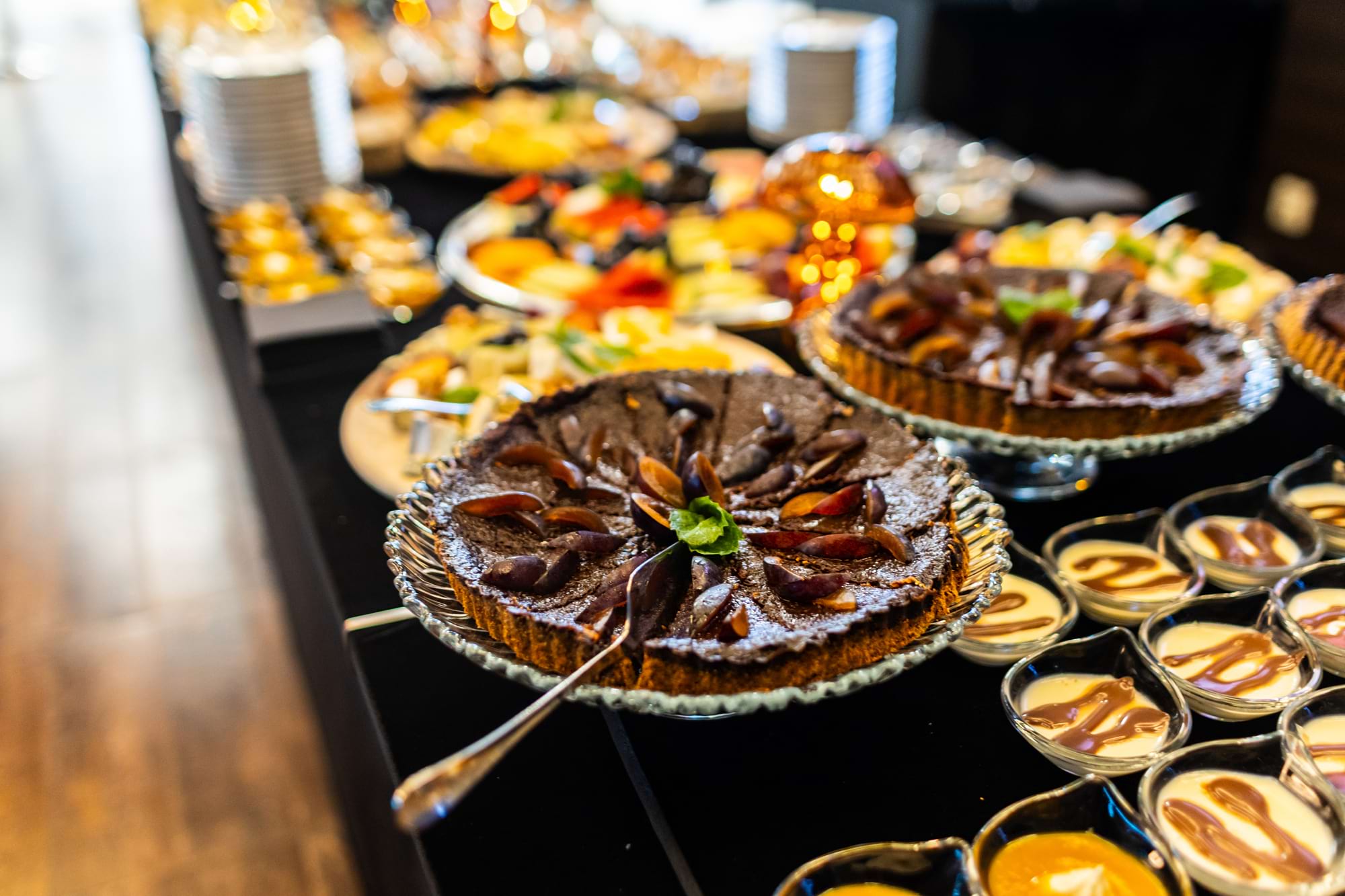 Czekoladowe ciasto z plasterkami i miętą na stole z deserami